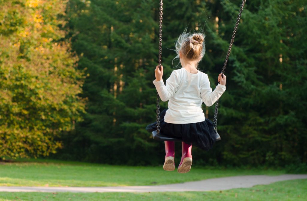 Little girl swinging at the park